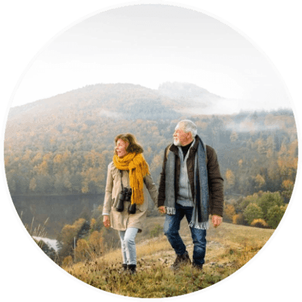 A man and woman walking on top of a hill.