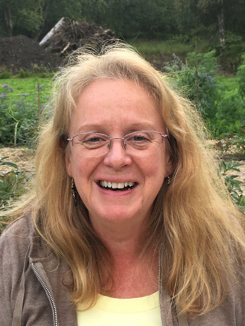 A woman with glasses smiling for the camera.